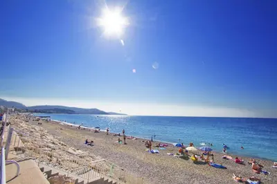 a group of people on a beach near the water at PROMENADE HOLIDAY - SUFFREN BEACH in Nice