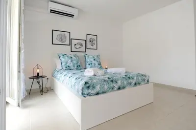 a white room with a bed with a blue blanket at Mini suite Othello - Five Stars Holiday House in Nice