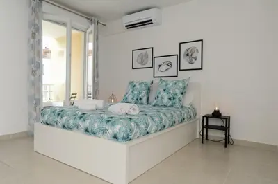 a white bedroom with a large bed with blue sheets at Mini suite Othello - Five Stars Holiday House in Nice