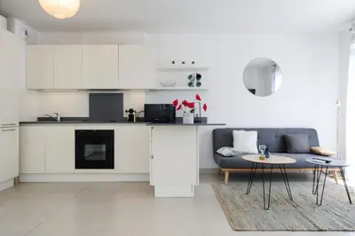 a white kitchen with a couch and a table at Mini suite Othello - Five Stars Holiday House in Nice