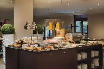 a buffet line with bread and pastries on a counter at NH Nice in Nice