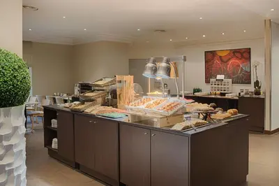 a bakery with a counter with food on it at NH Nice in Nice