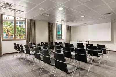 a conference room with black chairs and a white table at NH Nice in Nice