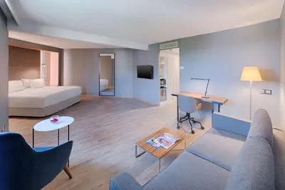 a living room with a bed and a couch and a table at NH Nice in Nice