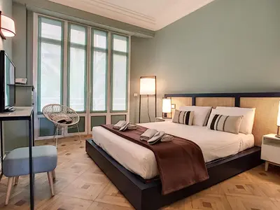 a bedroom with a large bed and a desk at Nestor&Jeeves - LAGOON PROMENADE - Central - Sea front in Nice