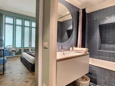 a bathroom with a sink and a tub and a bed at Nestor&Jeeves - LAGOON PROMENADE - Central - Sea front in Nice