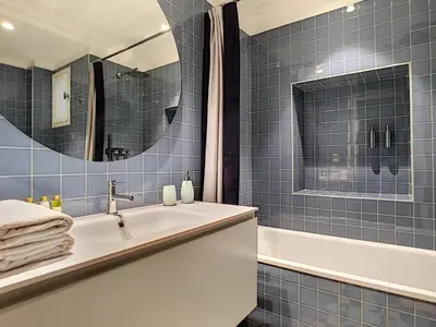 a blue tiled bathroom with a sink and a tub at Nestor&Jeeves - LAGOON PROMENADE - Central - Sea front in Nice