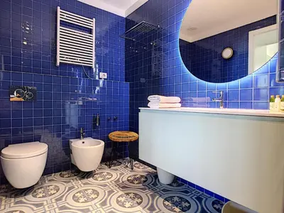 a blue tiled bathroom with a toilet and a sink at Nestor&Jeeves - LAGOON PROMENADE - Central - Sea front in Nice