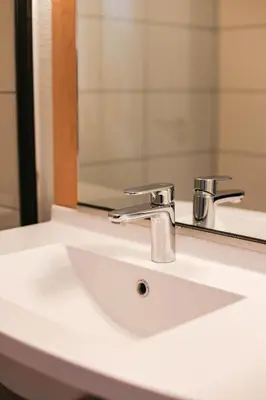 a bathroom sink with a faucet and a mirror at easyHotel Nice Old Town in Nice