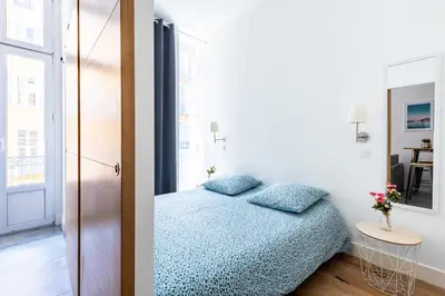 a small bedroom with a bed and a mirror at 1 CASSINI - Magnifique 2 pièces place Garibaldi - Balcon in Nice