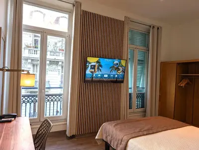 a bedroom with a bed and a large window at H33 Hôtel in Nice