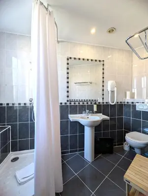 a bathroom with a shower and a sink and a toilet at H33 Hôtel in Nice