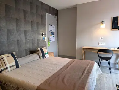 a bedroom with a large bed and a desk at H33 Hôtel in Nice