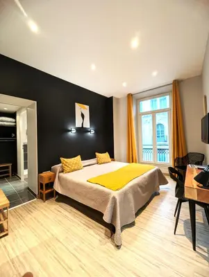 a bedroom with a large bed with yellow pillows at H33 Hôtel in Nice