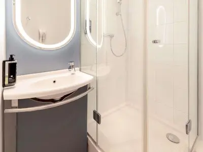 a bathroom with a shower and a bedroom at ibis Nice Centre Notre Dame in Nice