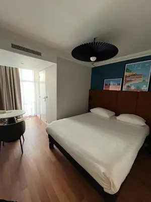 a bedroom with a large white bed and a table at ibis Nice Centre Notre Dame in Nice