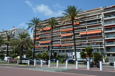 a tall building with palm trees in front of it at STUDIO PROMENADE FLORIDA BEACH in Nice
