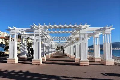 a row of white columns on a sidewalk next to the beach at 2P NEUF vue Promenade des Anglais / Tram 10min centre in Nice