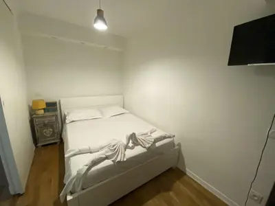 a small white bedroom with a bed and a television at PROMENADE HOLIDAY - OLD TOWN PANORAMIC in Nice