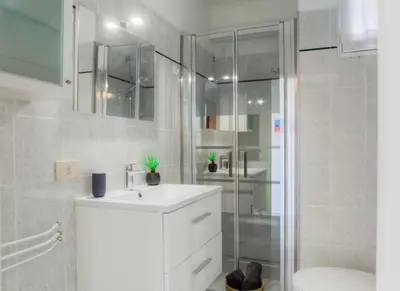 a white bathroom with a sink and a shower at #23 Henry IV Vue Panoramique Mer AC & Bright in Nice