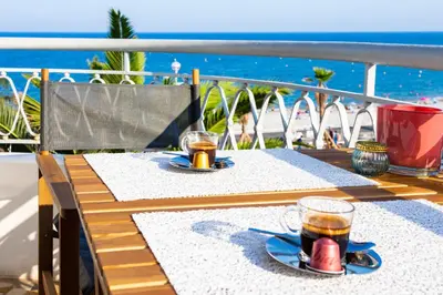 a table with two cups of tea on a balcony at #23 Henry IV Vue Panoramique Mer AC & Bright in Nice