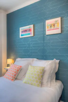 a bedroom with a blue wall and a bed with pillows at #23 Henry IV Vue Panoramique Mer AC & Bright in Nice
