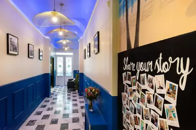 a hallway with a wall with pictures on it at Hôtel Locarno Nice in Nice
