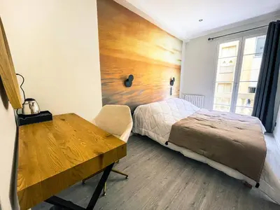 a bedroom with a bed and a wooden wall at Villa Berlioz in Nice