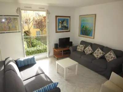 a living room with a couch and a table at Vieux Nice, grand 2P sur jardins, parking, calme, soleil in Nice