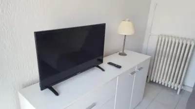 a flat screen tv sitting on top of a white dresser at Nice Centre Studio Proche Mer in Nice