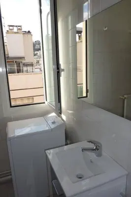 a white bathroom with a sink and a mirror at Nice Centre Studio Proche Mer in Nice