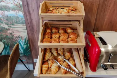 two wooden boxes filled with croissants on a table at Hôtel de France, un hôtel AMMI in Nice