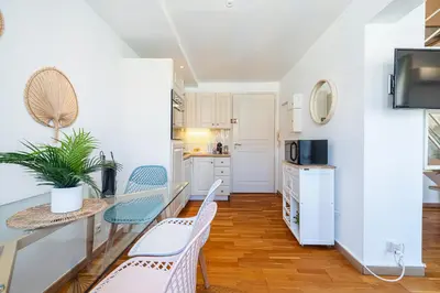 a kitchen with a microwave and a table with chairs at Massena Street - 1 Bdr Duplex with AC & Parking in Nice