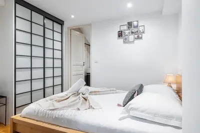 a bedroom with white walls and a bed with white sheets at Massena Street - 1 Bdr Duplex with AC & Parking in Nice
