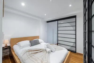 a bedroom with a large white bed and a window at Massena Street - 1 Bdr Duplex with AC & Parking in Nice