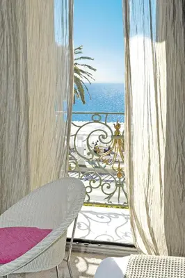 a view of the ocean from a balcony with a chair at Hôtel Le Royal Promenade des Anglais in Nice