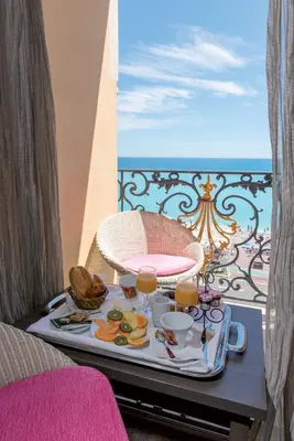 a tray of food on a table on a balcony at Hôtel Le Royal Promenade des Anglais in Nice