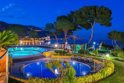 a view of a swimming pool at night at Hôtel Vacances Bleues Delcloy in Saint-Jean-Cap-Ferrat