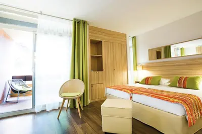 a hotel room with a bed and a window at Hôtel Vacances Bleues Delcloy in Saint-Jean-Cap-Ferrat