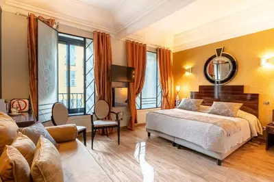a bedroom with a bed and a mirror at Hotel Le Meurice in Nice
