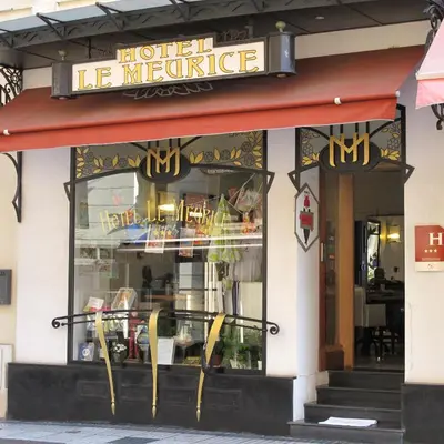 a hotel la muerte restaurant with yellow chairs in the window at Hotel Le Meurice in Nice