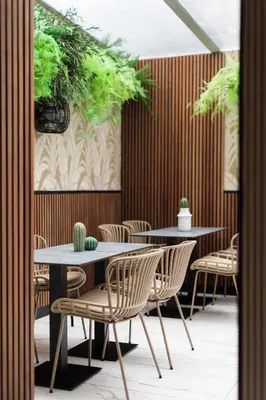 a woman sitting at a table in a restaurant at Hotel Khla Nice in Nice
