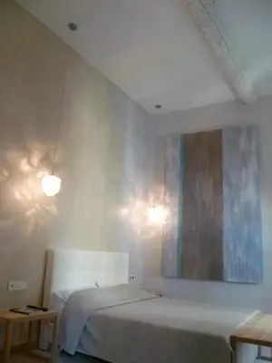 a bedroom with a bed and a painting on the wall at Hotel Rossetti in Nice