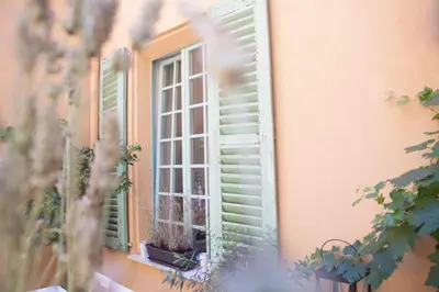 a window with green shutters on a building at Hotel Rossetti in Nice