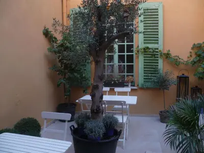 a table and a tree in front of a building at Hotel Rossetti in Nice