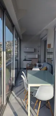 a living room with a blue table and chairs at Vue mer exceptionnelle entre Nice et Monaco in Villefranche-sur-Mer