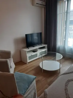 a living room with a tv and a glass table at T2 entièrement équipé, proche toutes commodités in Nice
