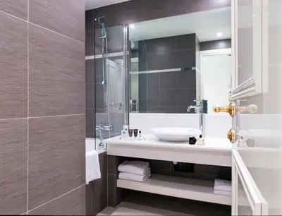 a bathroom with a sink and a glass shower at Hotel Aston La Scala in Nice