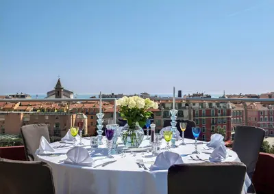 a table with a vase of flowers on top at Hotel Aston La Scala in Nice