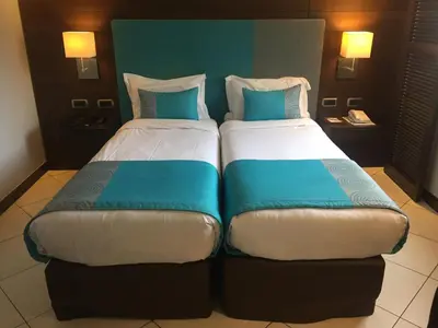 two beds sitting next to each other in a hotel room at Hotel Aston La Scala in Nice
